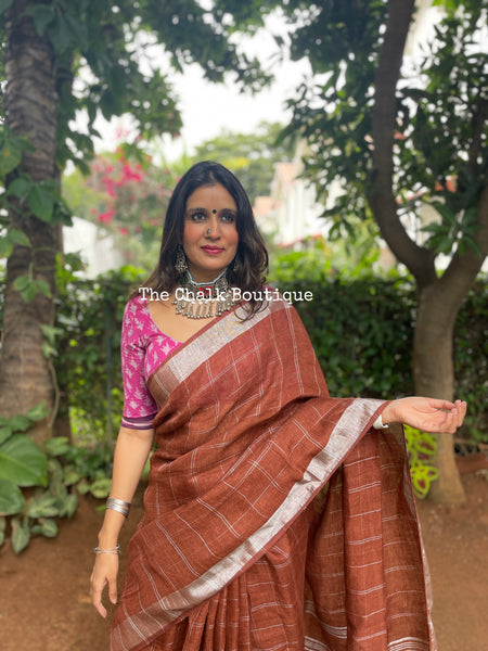 | Saundh | Brown checked linen saree with contrast zari border and tasseled palla.