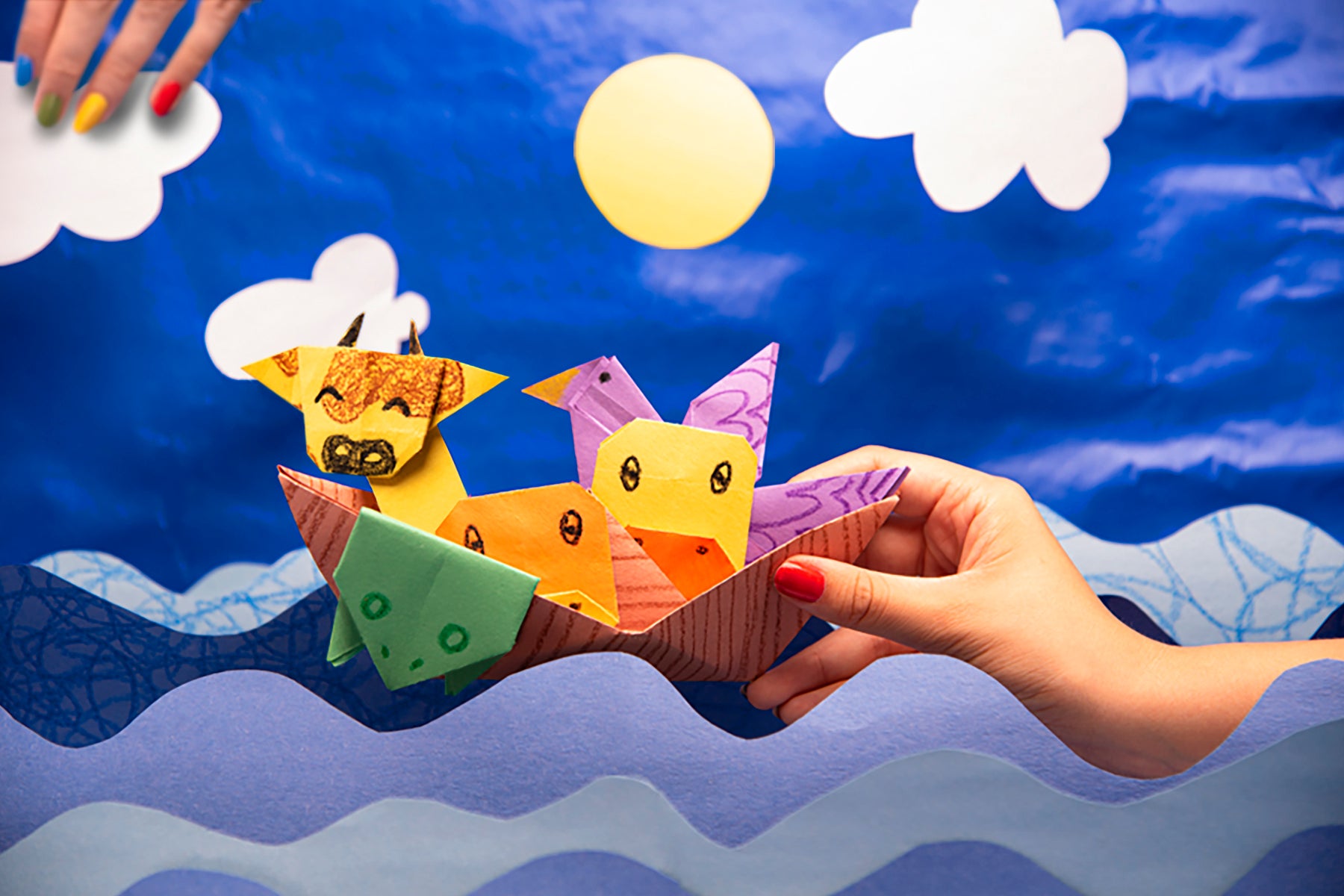 Origami Noah's arc in fun scene of ocean and sky made with blue construction paper