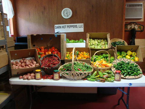 A farmer's market stand featuring Darn Hot Peppers' line up of peppers.