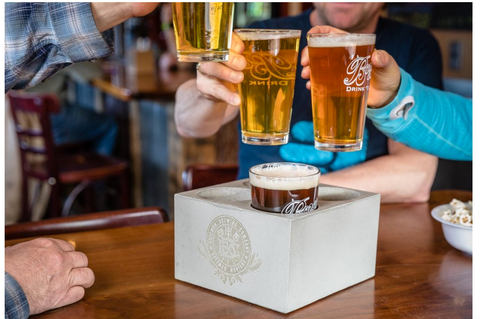 people cheers-ing over a beer chiller in a brewery