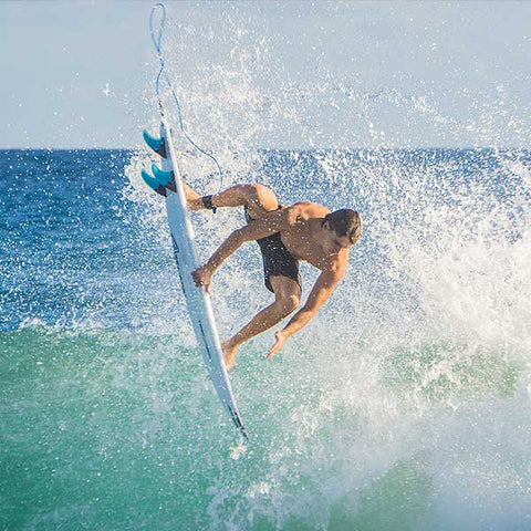 surfer doing a rail grab aerial in stoked board shorts