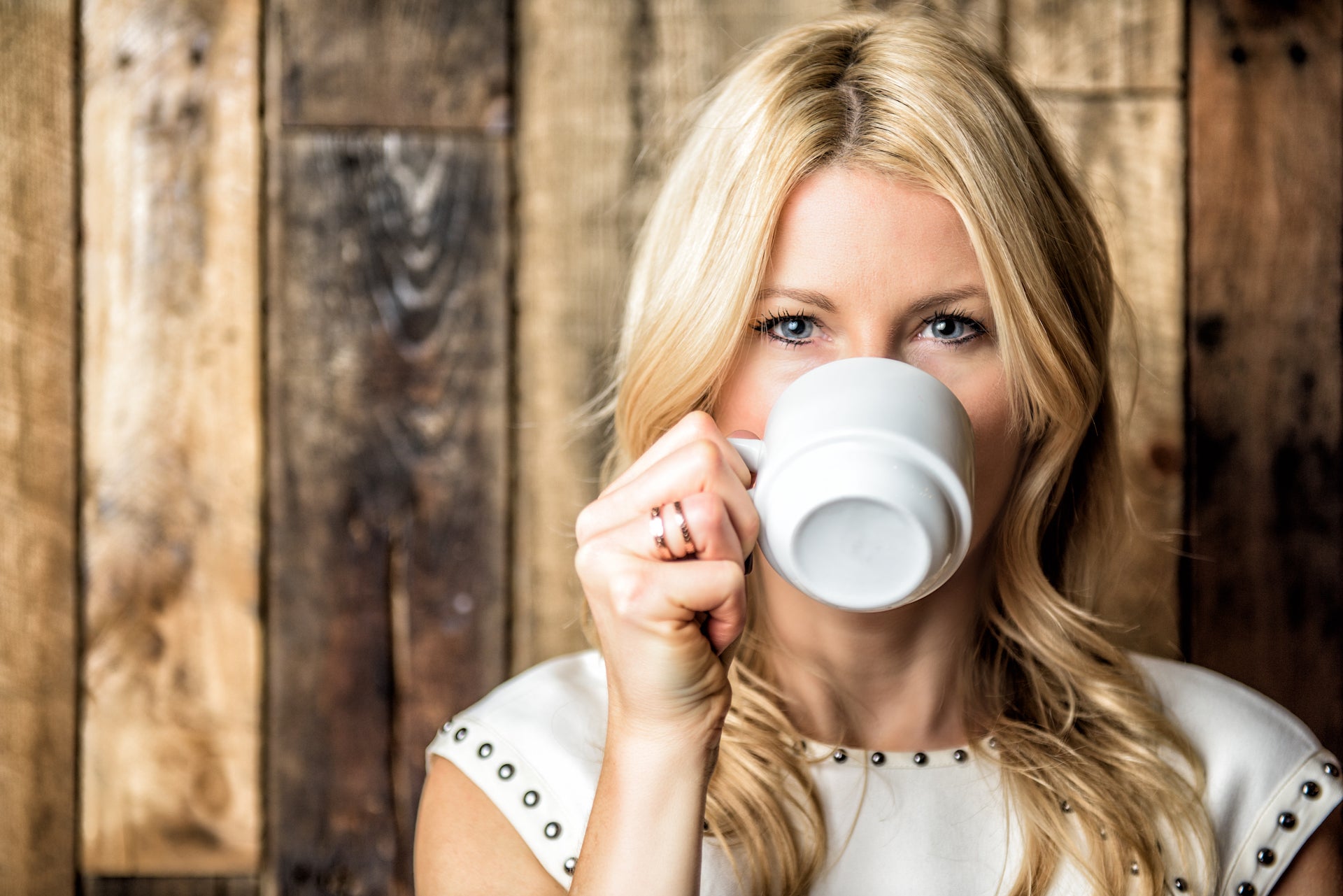 Theresa Krier founder of Big T NYC drinking tea in Nanette Lepore white dress