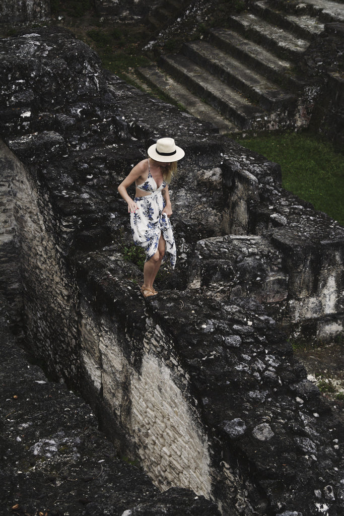 Alyssa standing on some of the ruins in Tikal National Park and exploring them as she is wearing a long white and blue maxi dress
