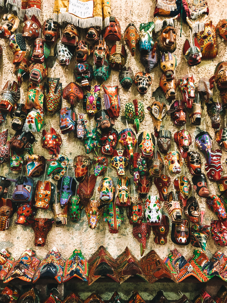 Wall of traditional masks hanging in Nimpot store, handmade crafts Antigua, learn about local traditions Guatemala, where to buy authentic handmade goods made locally in Antigua, handmade textiles Antigua