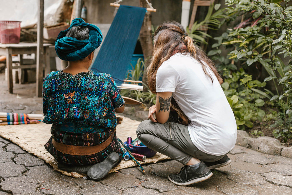 Hiptipico long-term artisan partner Teresa instructing tour participant to weave, ethical weaving tours, artisan home visits, Guatemala artisan visit