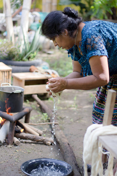 Long-term artisan partner Rosa wrings water out of fabric for dying, authentic naturally died products, Guatemala ethical fashion, maya weavers