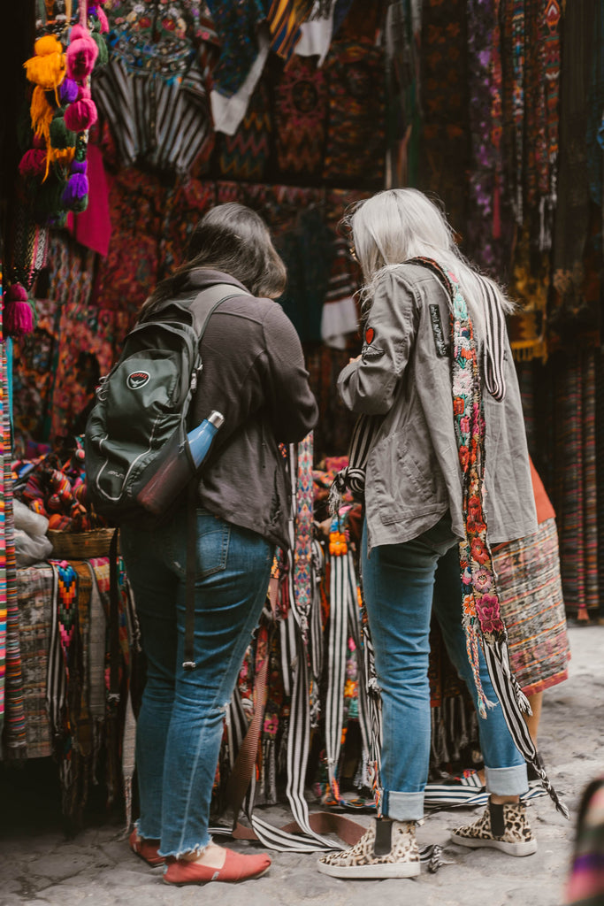 Hiptipico founder works with client at colorful artisan stall in Guatemalan market, Ethical textile sourcing, Central American textiles sourced ethically, Ethical fashion bloggers in Guatemala