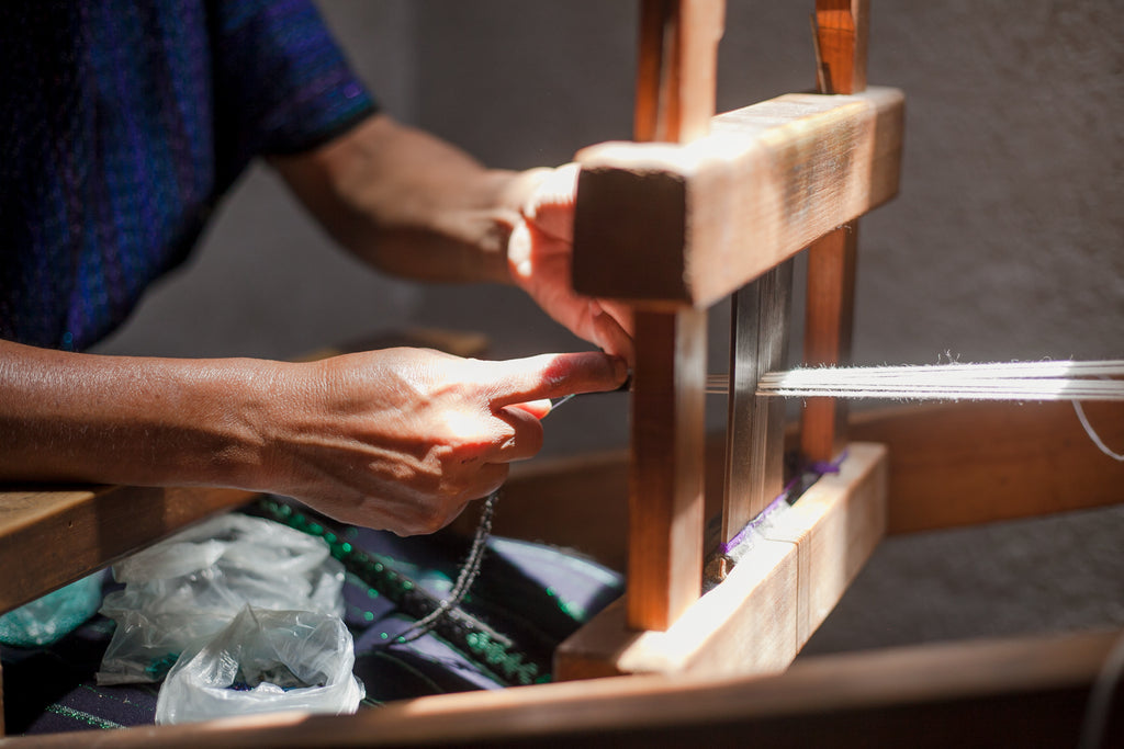 A close up of Maria's hands flying as they work to create the products on the pedal loom, maya tocoyal, traditional maya clothing, maya weaving in lake atitlan