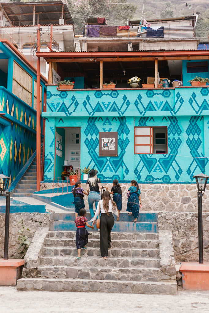 Hiptipico founder Alyssa, She Is Not Lost blogger Carina, and local kids walk up steps through blue-green town square towards tienda and artisan workshop, ethical travel blogs, ethical travel bloggers, where to go in Santa Catarina
