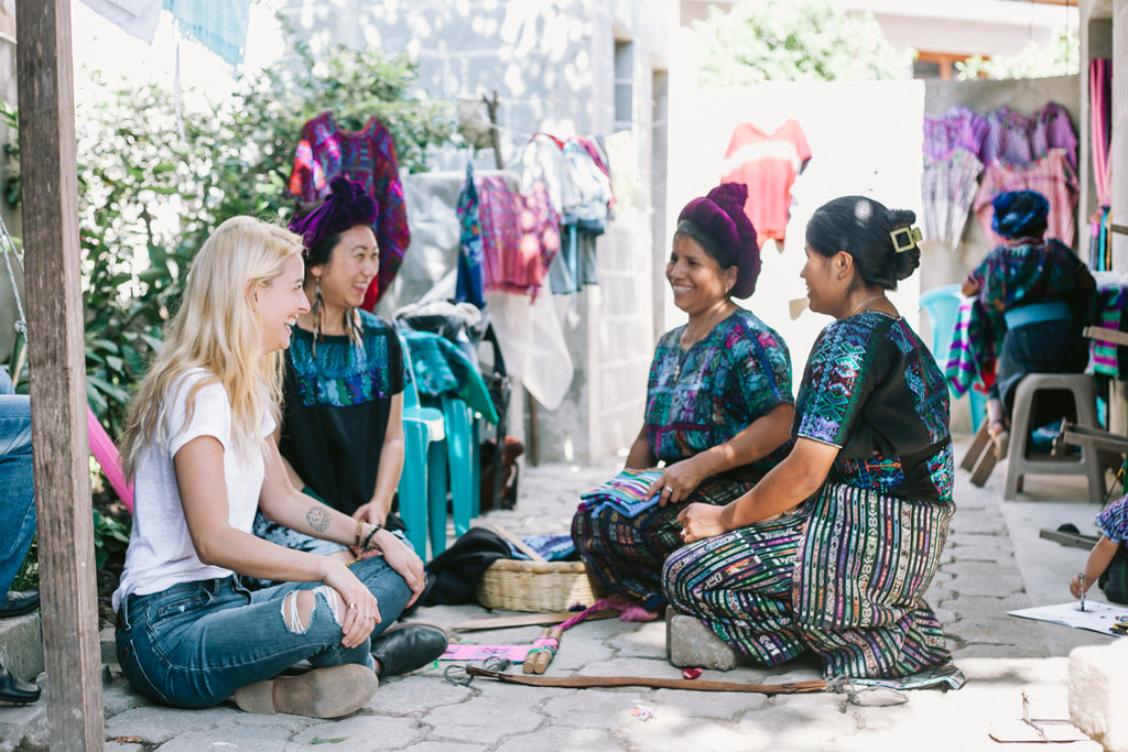 Hiptipico founder Alyssa laughs with 3 Artisan Partners dressed in traditional blue corte in home workshop, social impact fashion companies, ethical fashion brands in Guatemala, best B-Corp certified brands