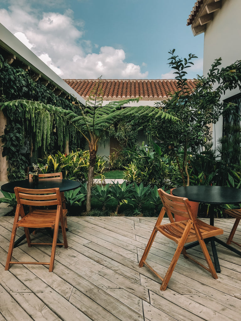 Wood patio with tables and chairs over looks garden space at Good Hotel in Guatemala, social impact businesses in Guatemala, where to stay in Guatemala, best places to stay in Antigua, socially conscious hotels in Antigua Guatemala, coolest places to stay in Guatemala, ethical travel blogs about Guatemala