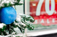 A picture of a blue ornament on a Christmas tree.