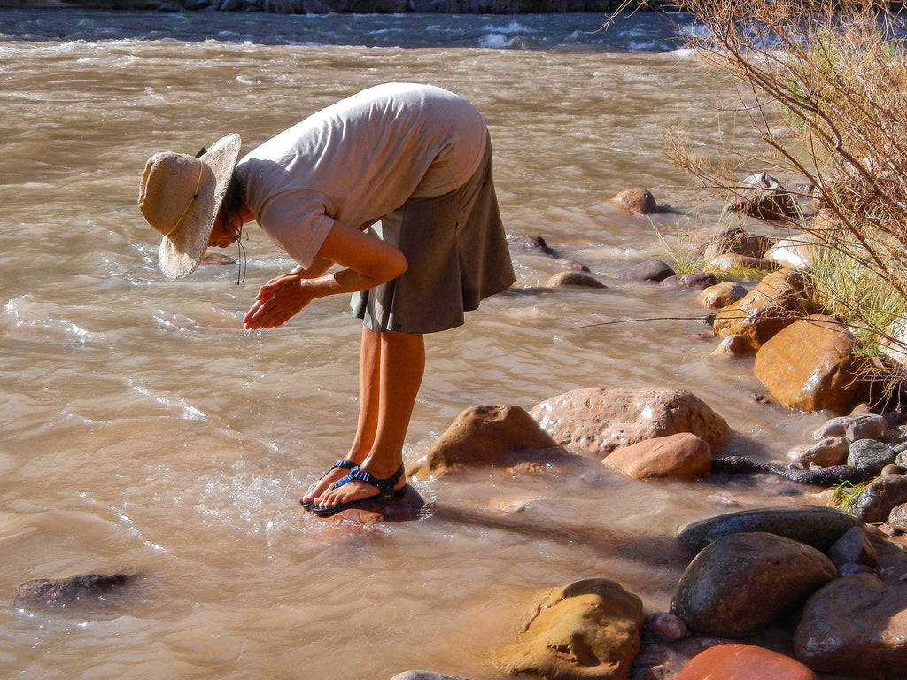 A person washing their feet in the Colorado river