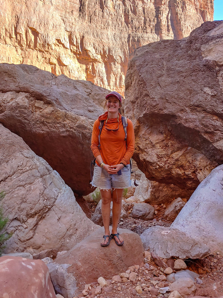 A person smiling while hiking in a slot canyon along the Colorado River