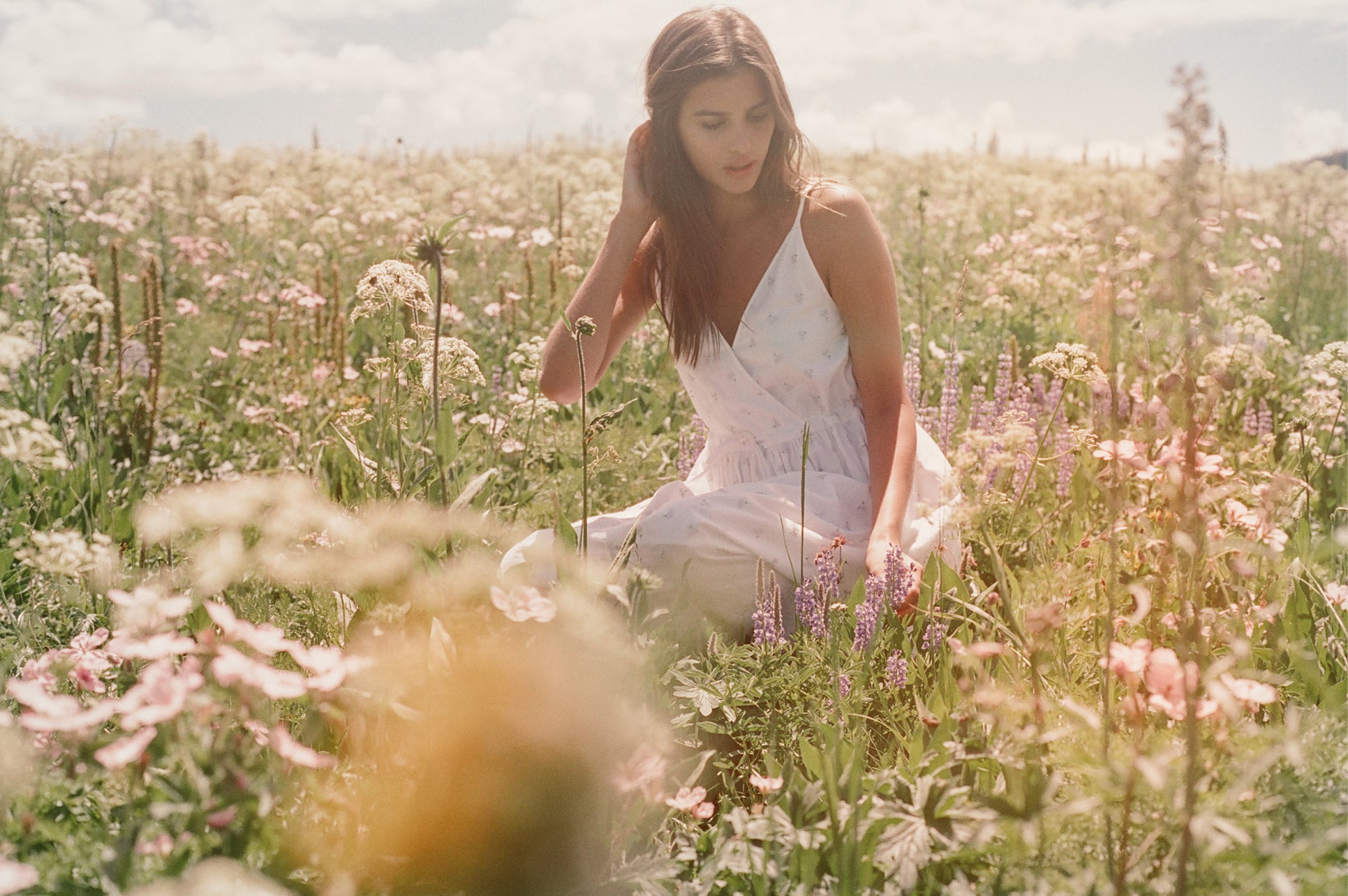 We’re inspired daily by the beauty of Mother Earth. Karina sits in a field of wildflowers in Wyoming.