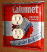 Outlet cover made from a vintage Calumet Baking Powder tin.