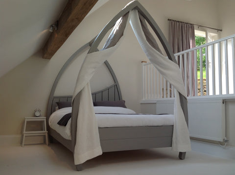 Grey four poster bed made from solid hardwood.