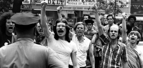 Image of the STONEWALL RIOTS, 1969. Men holding hands up and shouting fed up with laws established then