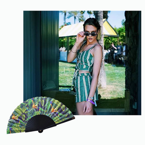 Instagrammer victoria.jancke at Coachella 2019 wearing green and white shorts with Khu Khu green parakeet hand fan