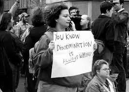 Woman holding up sign Discrimination is ALWAYS WRONG at one of the original LGBT marches