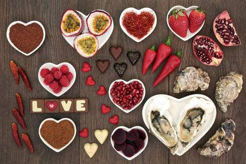 Heart shared bowls filled with assorted foods on wooden background