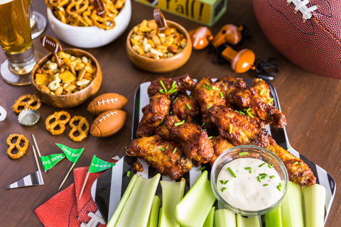 Cooked chicken wings on a plate with celery and bowl with dipping sauce