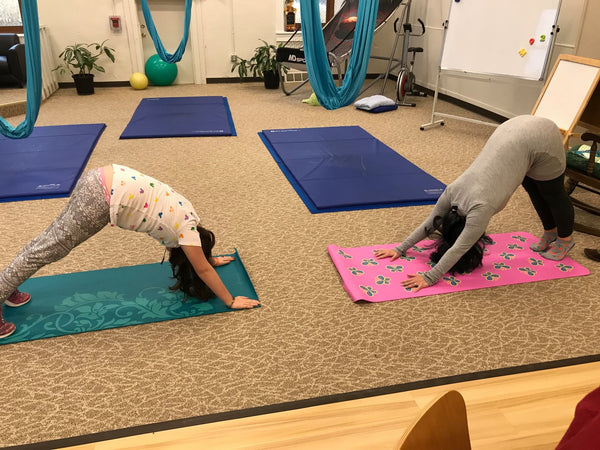 Two students using yoga mats in school