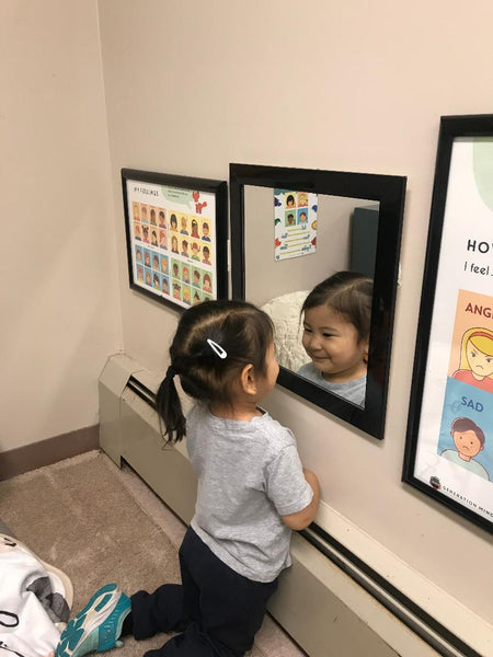 Young girl observing her face in a mirror