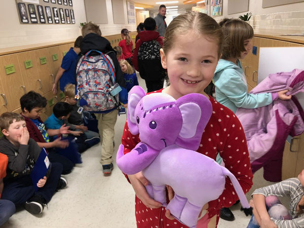 Girl holding Generation Mindful's Violet Elephant SnuggleBuddies