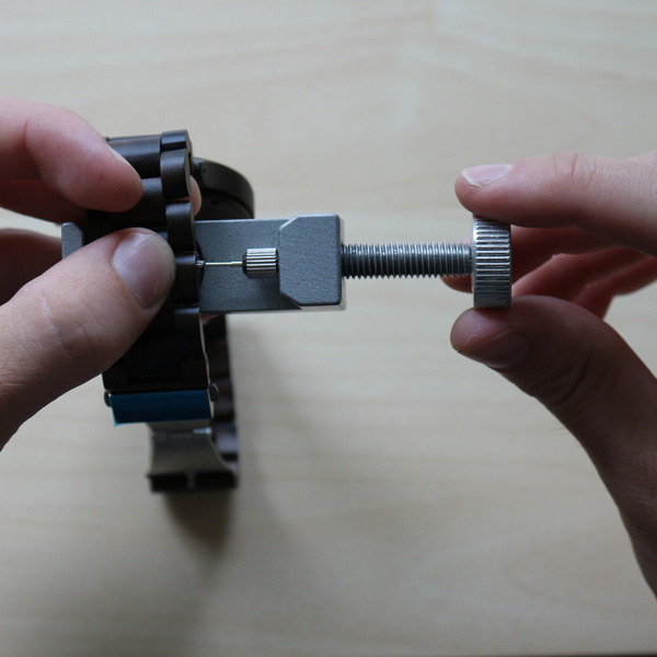 Person Resizing Wooden Watch using a Watch Resizing Tool