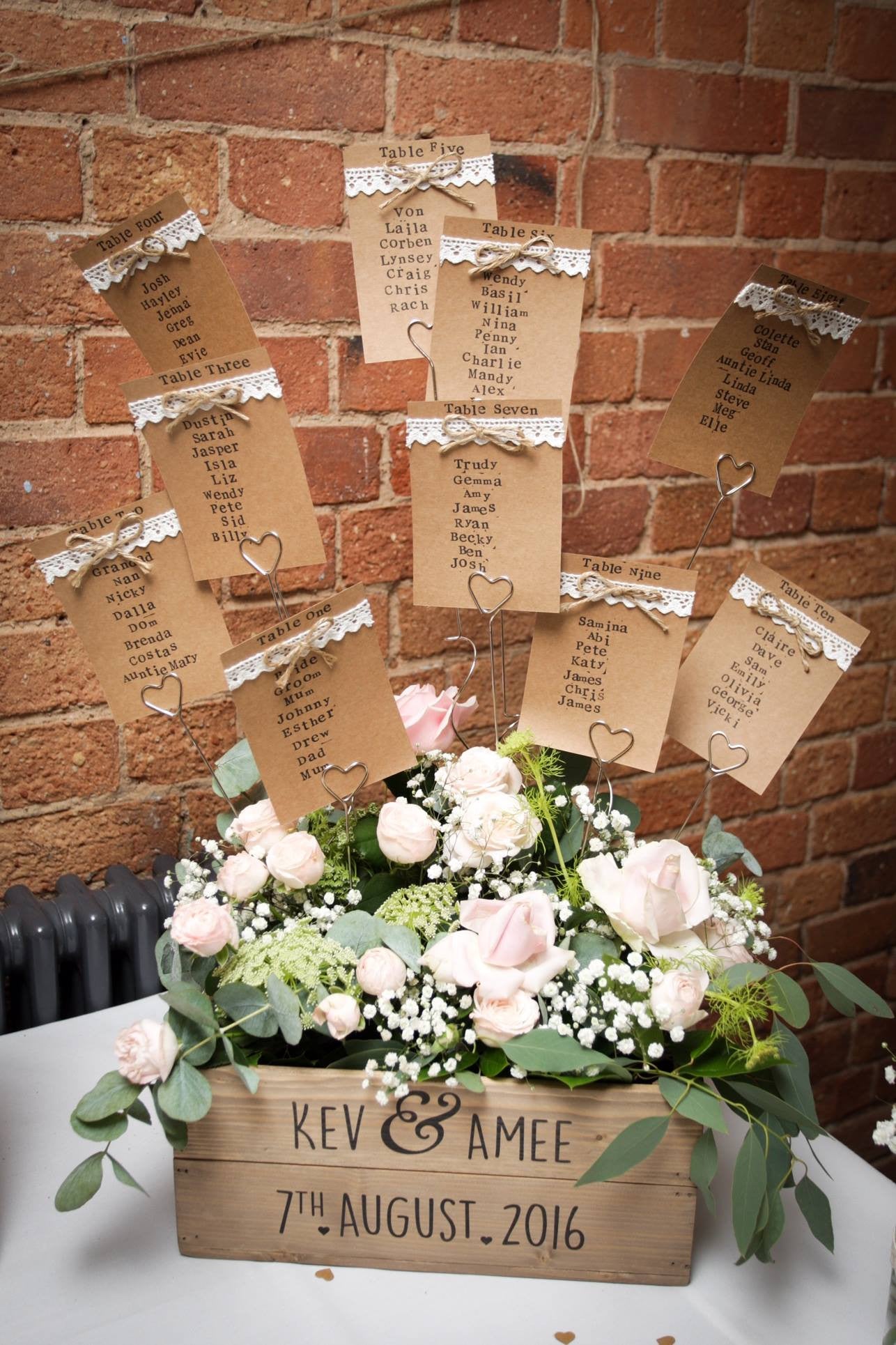 Wooden crate table seating arrangement with pink Roses, white Gypsophila and foliage.