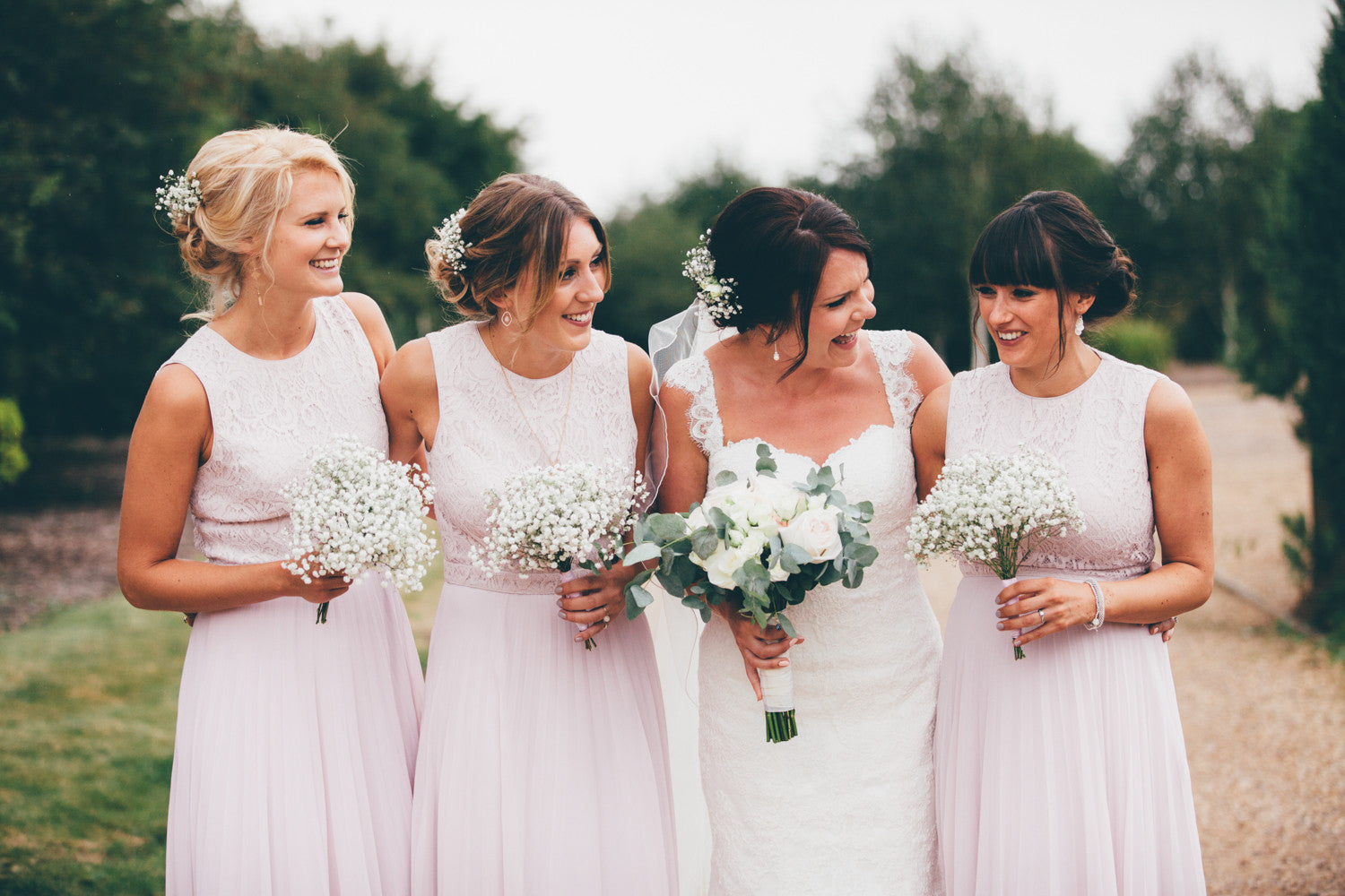 Bride and Bridesmaid's with their wedding flowers in shades of pink and white.