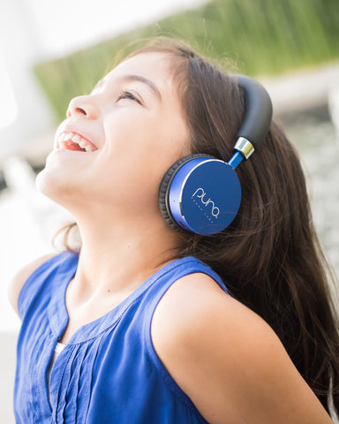 Little girl wearing blue Puro Sound headphones