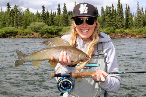 Young woman with fish caught on light fly rod.