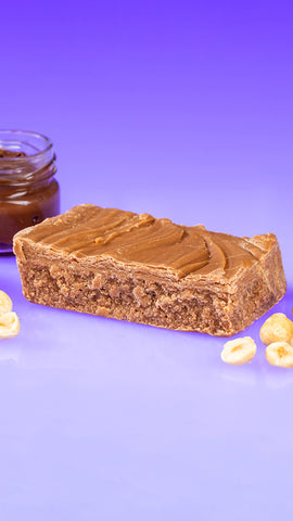 Nutella Fudge Bar surrounded by hazelnuts and a jar of Nutella 