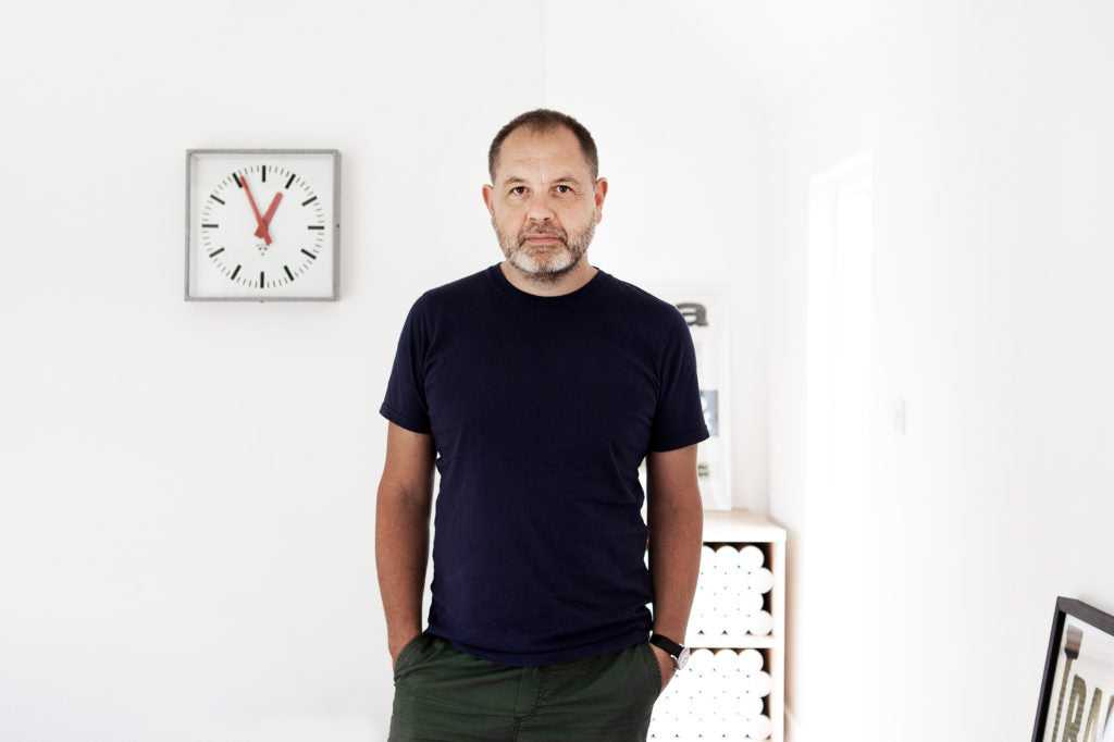 man standing in front of a clock