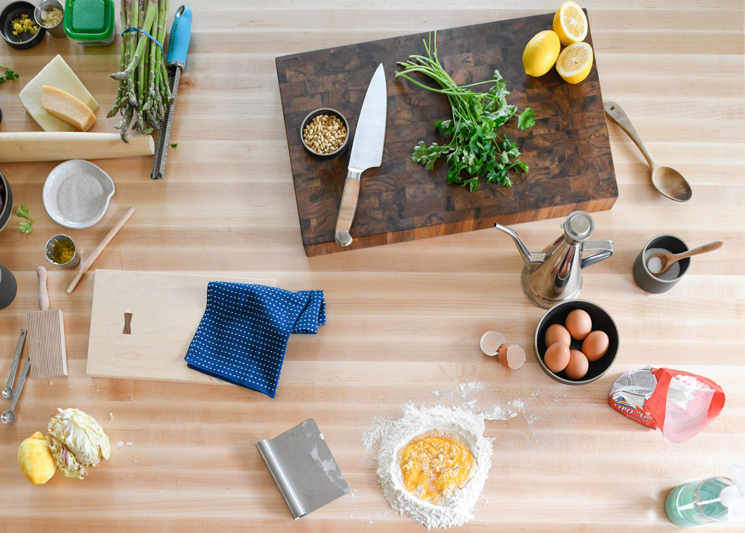 table with food and utensils on it and cutting board