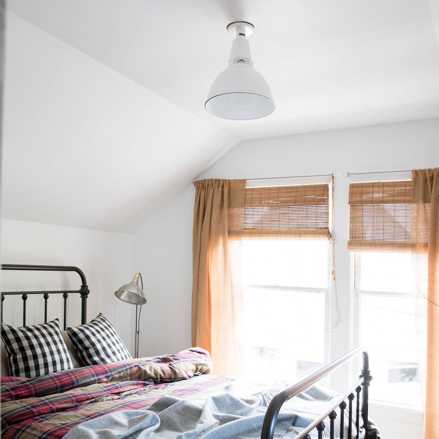 bedroom with a bed and a window and a white ceiling light fixture