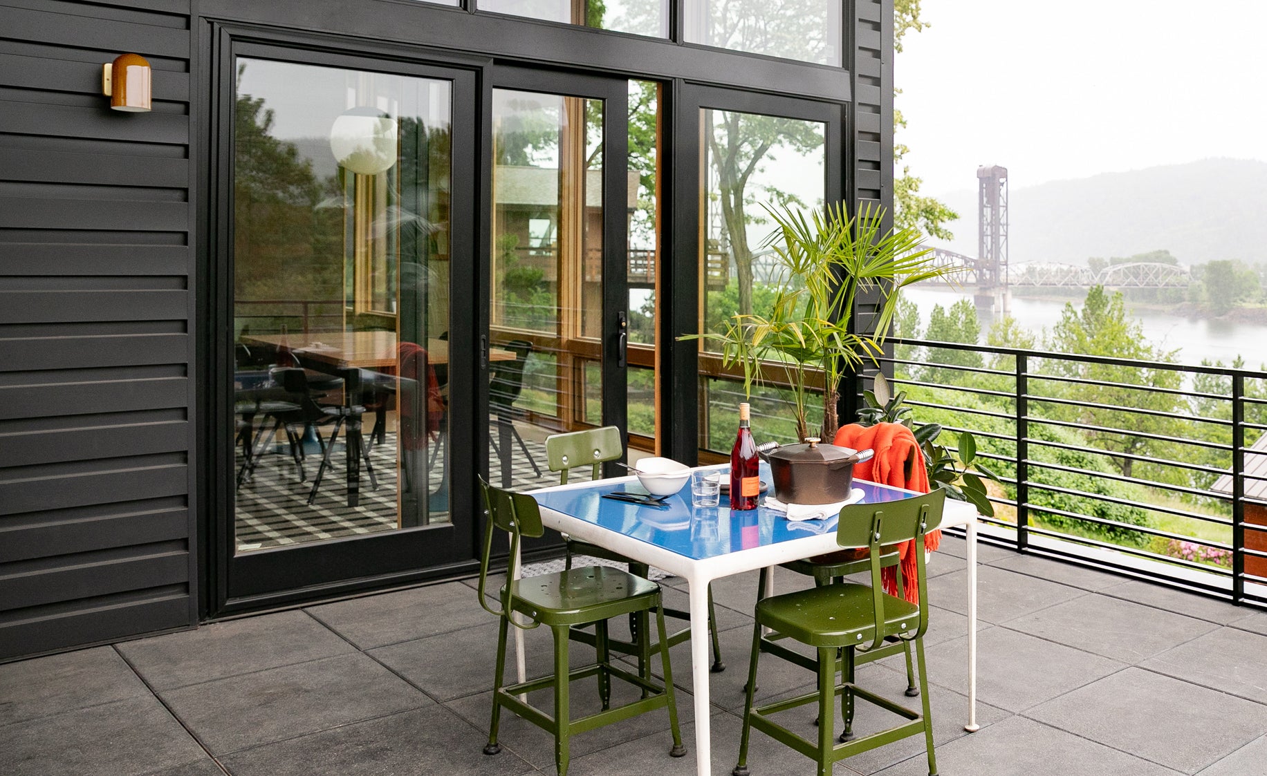 table and chairs outside on a balcony and a plant