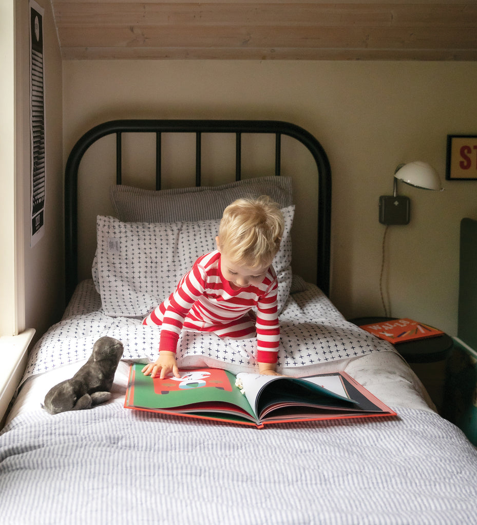 small child on a bed with a book 