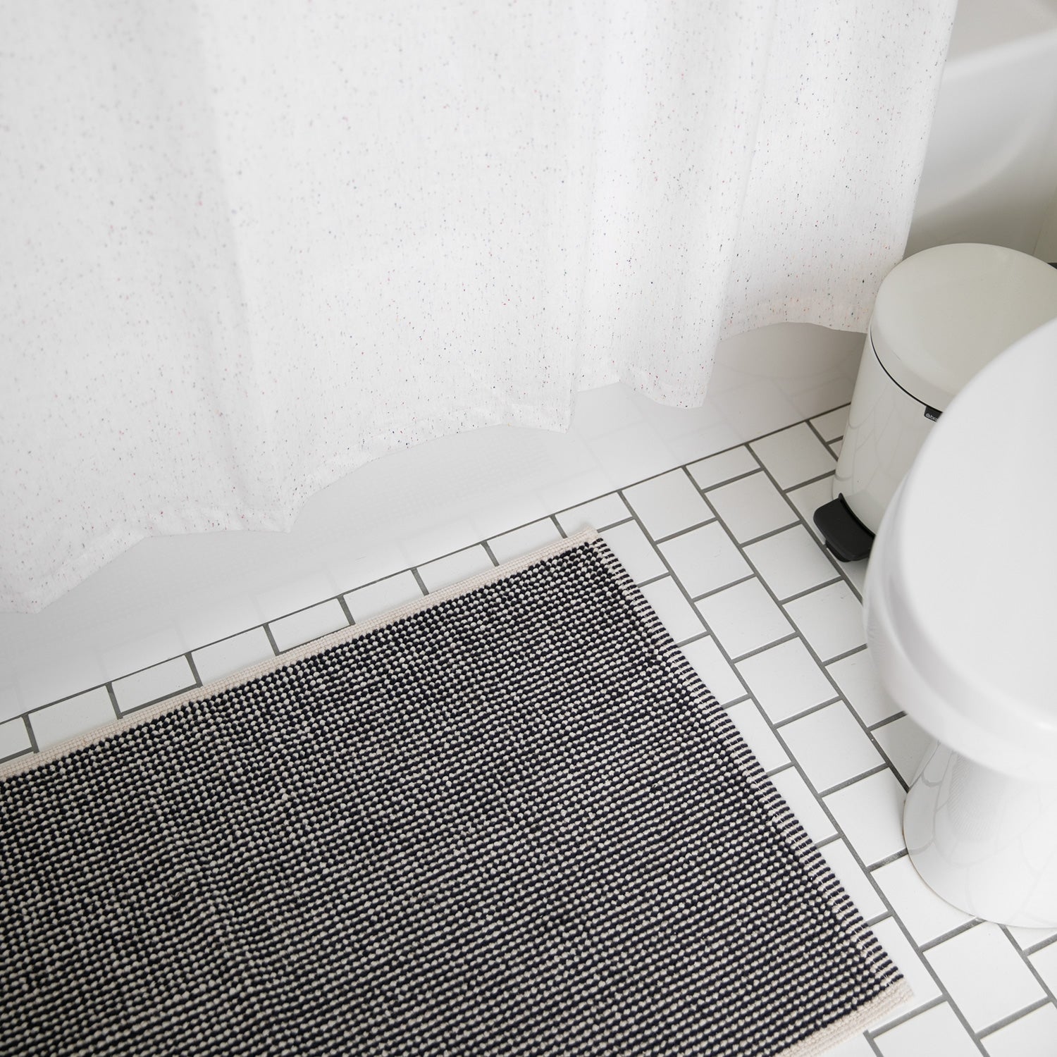 bathroom with a tile floor and a rug