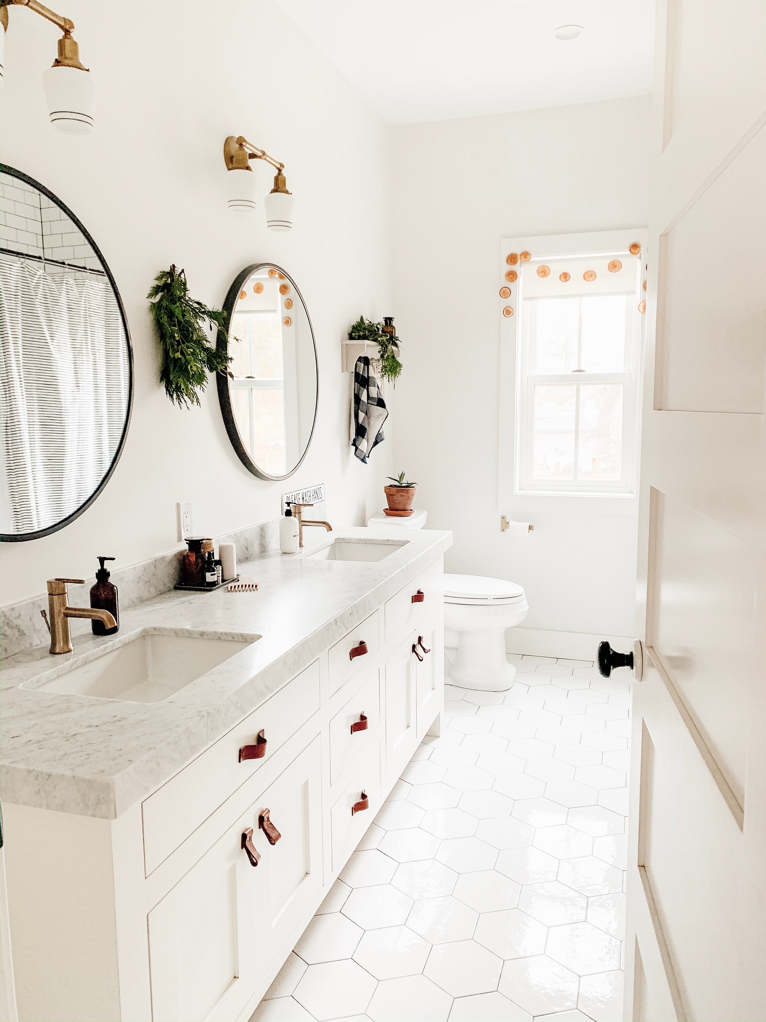 bathroom with a white counter and round mirrors