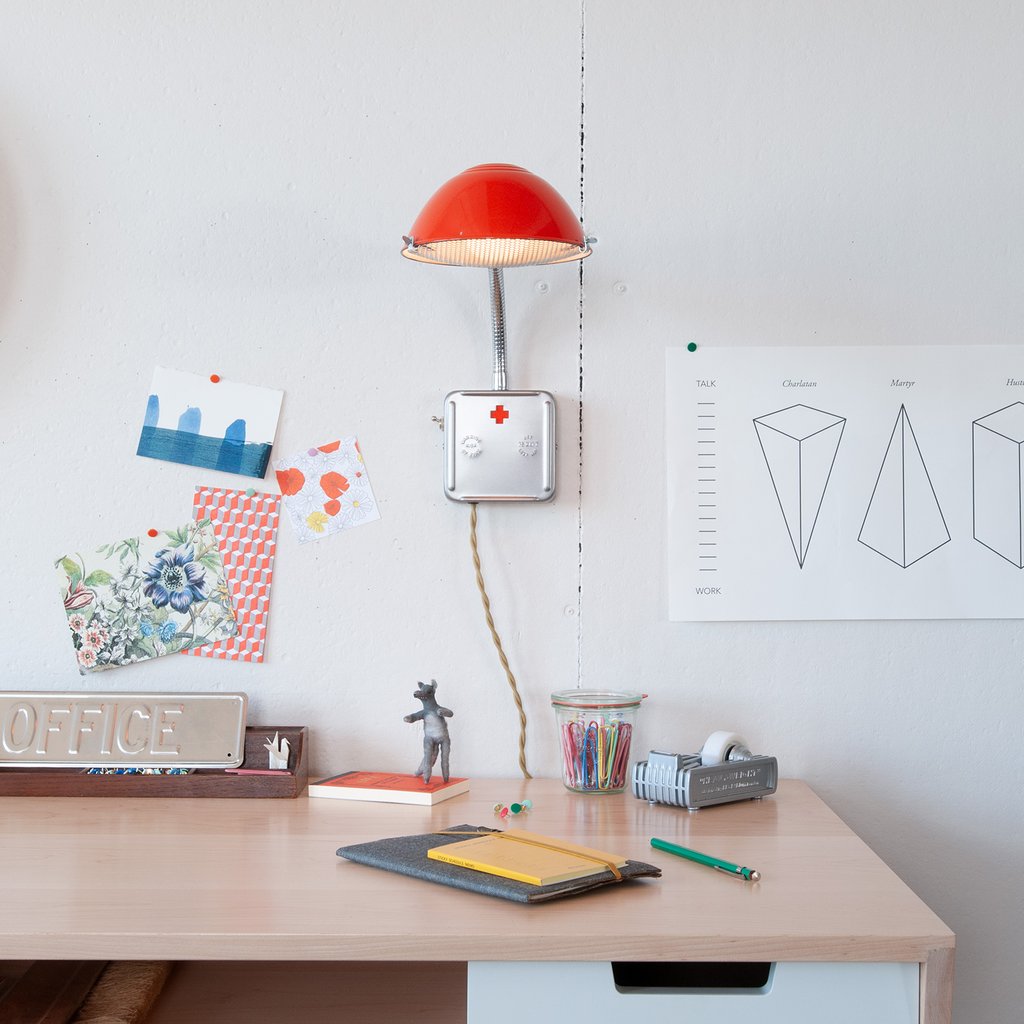 desk with stationery on it and a red sconce