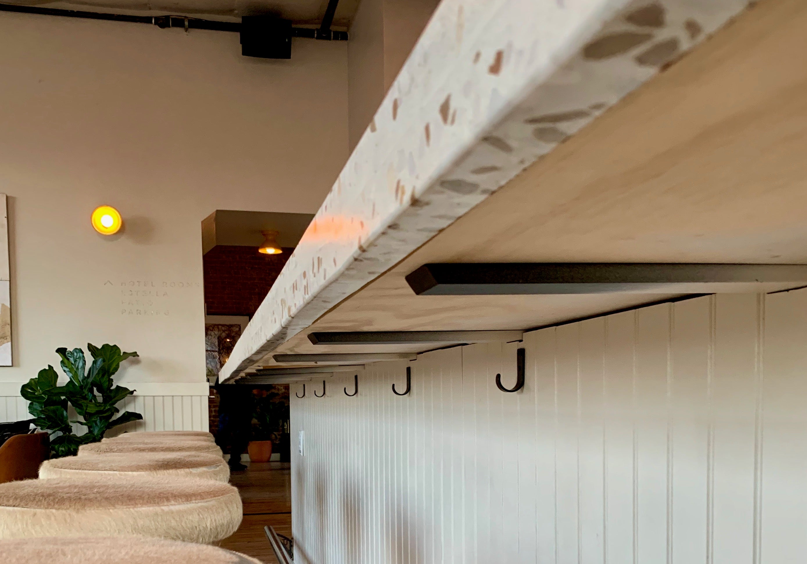 barstools next to a bar with hooks under