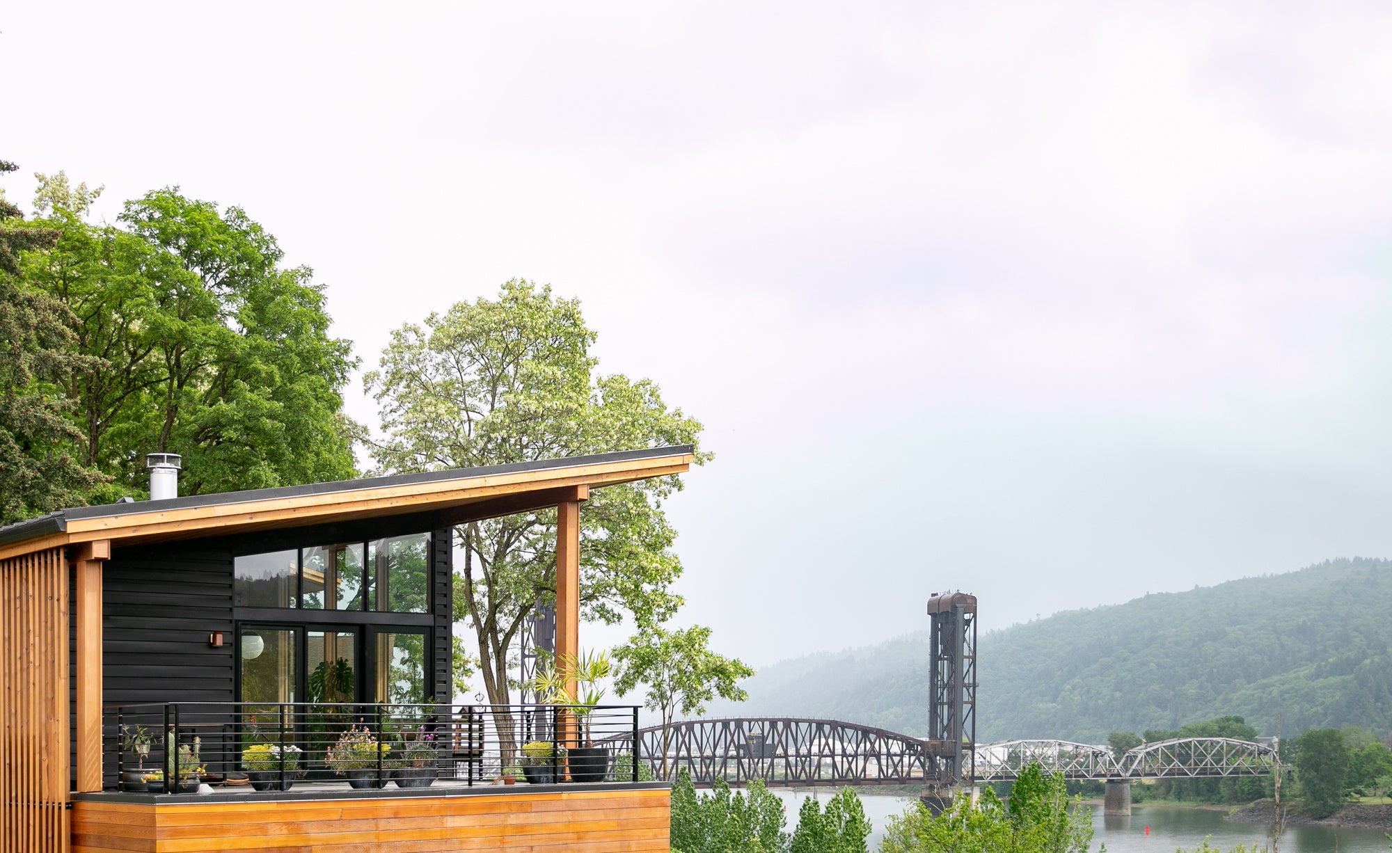 wooden building with a bridge and trees in the background