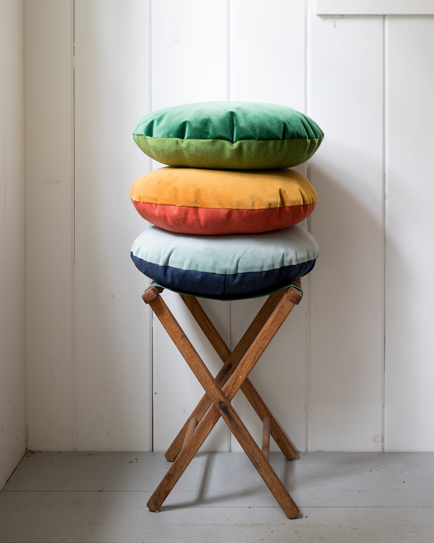 stool with a stack of round pillows on it
