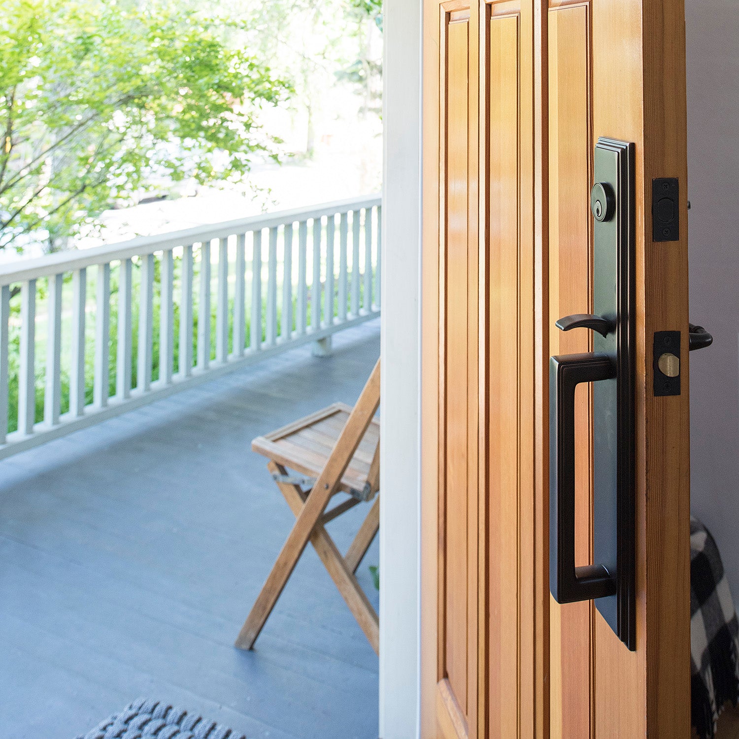 door with a handle with the view of a porch and a chair outside