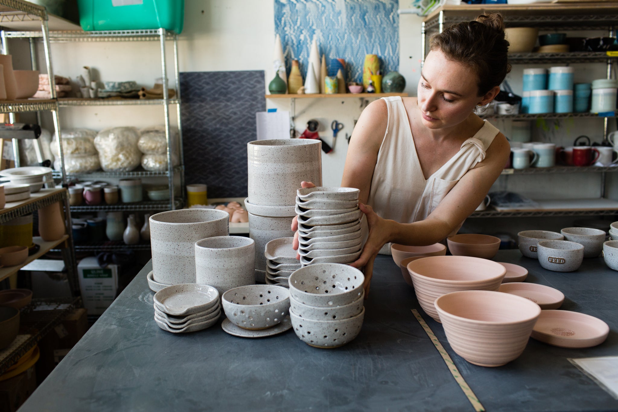 person stacking clay dishware
