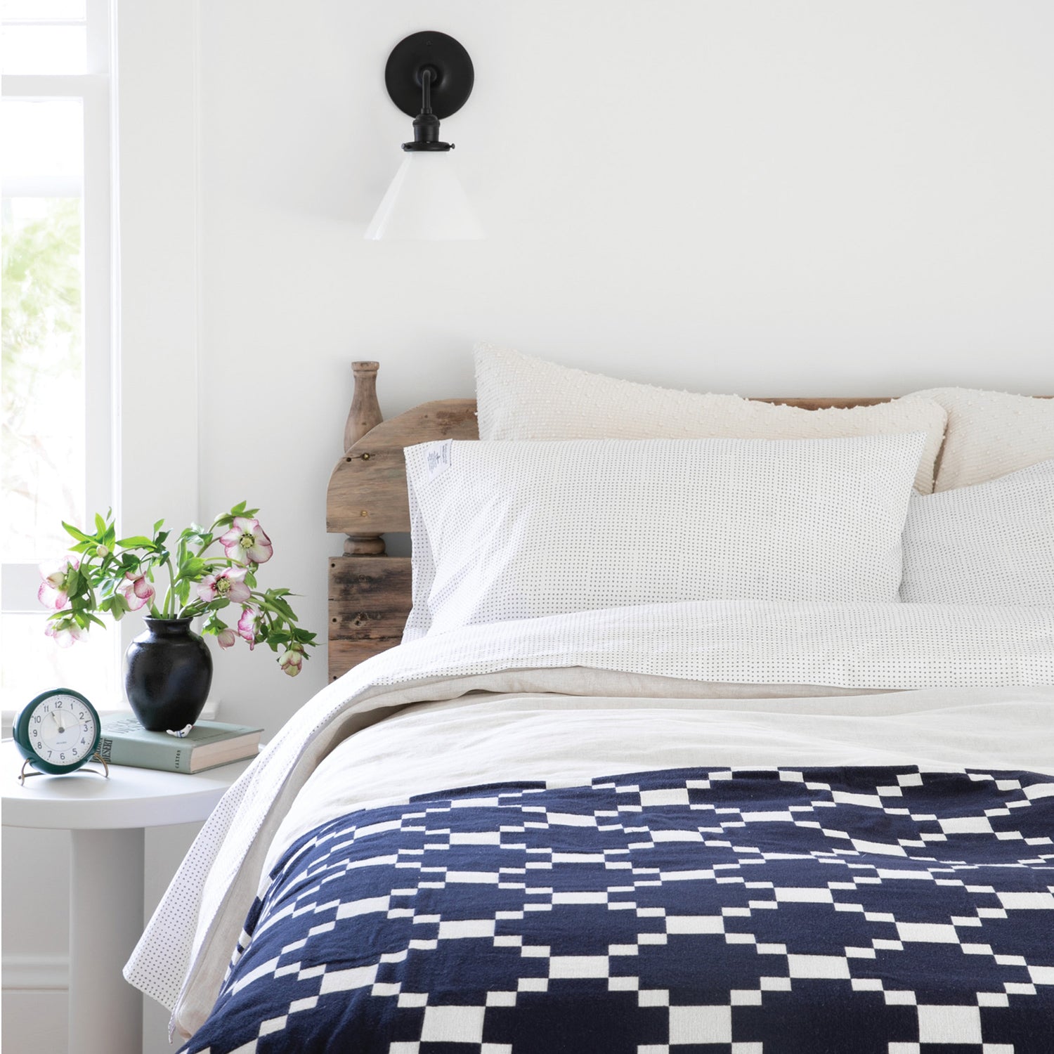 bed with a navy and white bed spread
