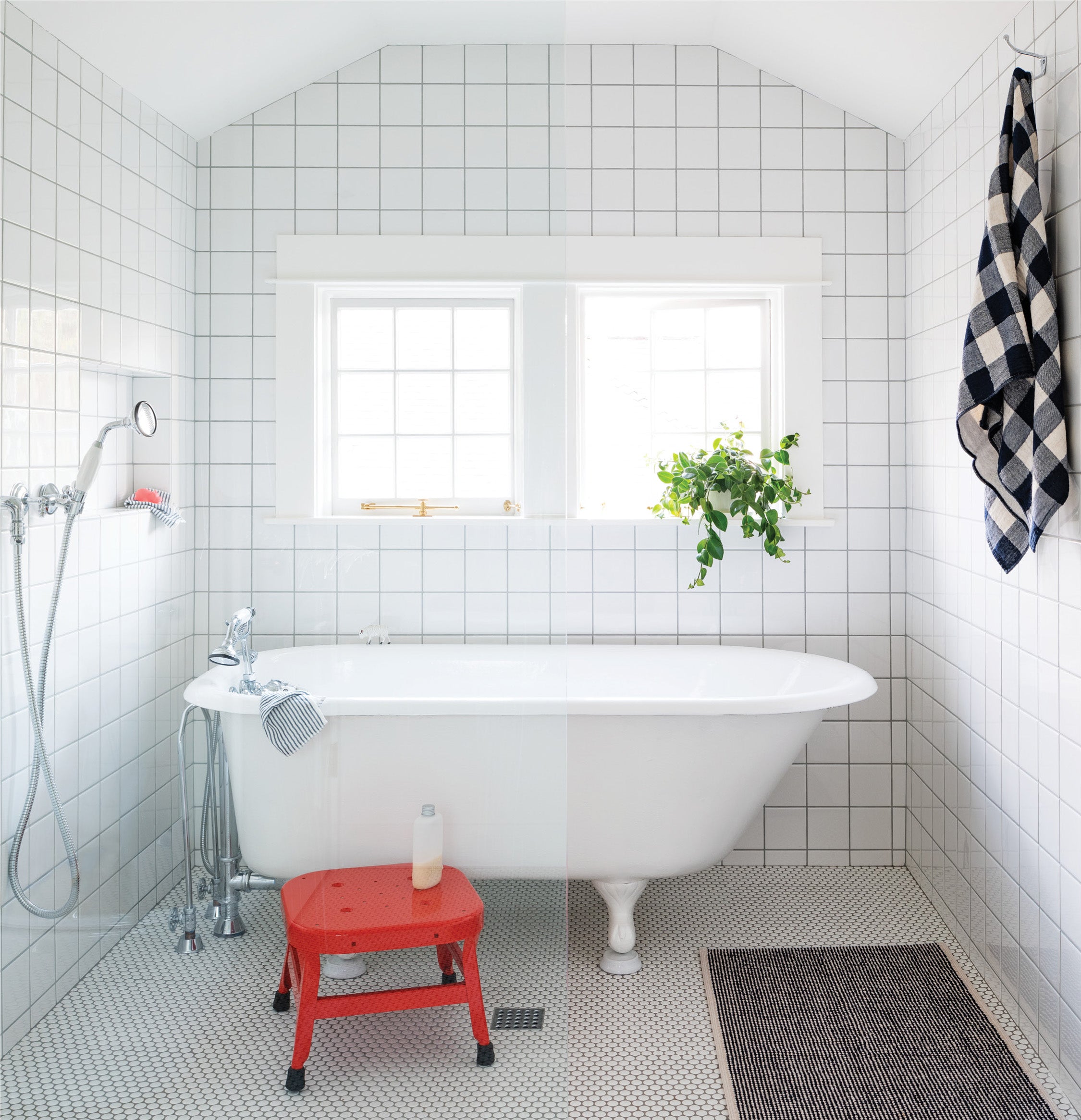 bathroom with a white tub and a red stool